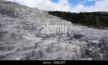 Image majestueuse d'un magnifique paysage de sources chaudes en travertin blanc, avec un horizon pittoresque de collines ondulantes et un ciel bleu vibrant Banque D'Images