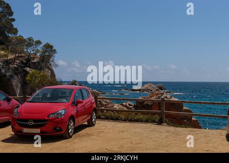 Barcelone, Espagne - 14 août 2023 Opel Corsa E sur la plage idyllique de la Costa Brava : symbole de voyage en voiture Banque D'Images