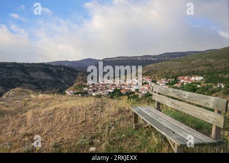 Banc au sommet de la montagne avec de belles vues sur la vallée et un village de maisons blanches appelé Huelamo, Cuenca. Espagne. Banque D'Images