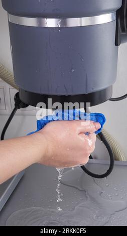 Fuite d'élimination des déchets sous un évier, broyeur d'ordures cassé Banque D'Images