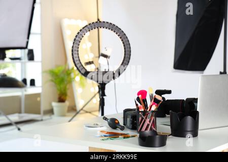 Équipement photo professionnel avec pinceaux de maquillage sur table en studio, gros plan Banque D'Images