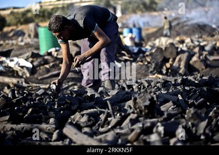 Bildnummer : 56261948 Datum : 08.11.2011 Copyright : imago/Xinhua (111108) -- YABAD, 8 novembre 2011 (Xinhua) -- Un ouvrier palestinien travaille sur un site de production de charbon dans la ville de Yabad, en Cisjordanie, près de Djénine, le 8 novembre 2011. L ' industrie charbonnière, qui consiste à brûler de grandes quantités de bois pendant plus de 21 jours, pollue gravement l ' environnement et crée un risque élevé de problèmes respiratoires pour les travailleurs palestiniens et les habitants de la région. (Xinhua/Fadi Arouri) MIDEAST-CISJORDANIE-INDUSTRIE CHARBONNIÈRE-PALESTINIENS PUBLICATIONxNOTxINxCHN Wirtschaft Köhlerei Köhler Holzkohle Produktion x1x xkg 2011 quer Banque D'Images