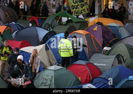 Bildnummer : 56292206 Datum : 17.11.2011 Copyright : imago/Xinhua (111118) -- LONDRES, 18 novembre 2011 (Xinhua) -- Un policier parle à un manifestant dans le camping près de la Bourse de Londres, le 17 novembre 2011. Le délai légal pour les manifestants anticapitalistes devant la cathédrale Saint-Paul, à côté de la Bourse de Londres, pour quitter leur camp de tentes est passé à 6 heures jeudi sans signe de départ des manifestants. Les manifestants, qui ont installé leur camp le 15 octobre devant la cathédrale St Paul dans le centre de Londres, font maintenant face à une action en justice devant la haute Cour pour les déplacer Banque D'Images