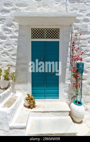 Entrée de maison traditionnelle colorée des îles des Cyclades, avec une porte verte en bois et un mur blanchi blanc, sur l'île de Syros, Cyclades, Grèce. Banque D'Images