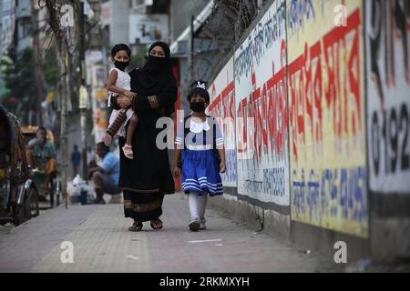 DHAKA, BANGLADESH - 16 MARS 2020 : les gens portent des masques faciaux marchent le long du sentier au milieu de la propagation du nouveau coronavirus à Dhaka, Bangladesh, le 16 mars 2020. Le gouvernement du Bangladesh ferme tous les établissements d'enseignement à travers le pays en raison de la propagation du nouveau coronavirus. Banque D'Images