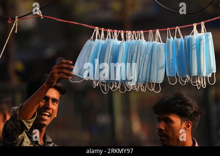 Masques faciaux suspendus sur corde à vendre pendant la propagation du COVID-19 à Dhaka, Bangladesh, le 9 mars 2020. Banque D'Images