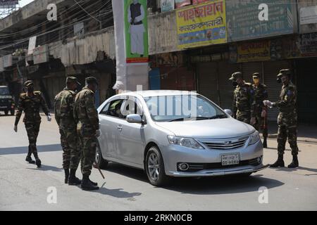 DHAKA, BANGLADESH - 27 MARS 2020 : les soldats de l’armée conscients du fait que les gens en général doivent utiliser le masque, restent à la maison alors qu’ils patrouillent dans les rues pendant le confinement national comme mesure préventive contre l’épidémie de coronavirus COVID-19, à Dhaka, au Bangladesh, le 27 mars 2020. Banque D'Images