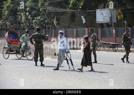 DHAKA, BANGLADESH - 27 MARS 2020 : les soldats de l’armée conscients du fait que les gens en général doivent utiliser le masque, restent à la maison alors qu’ils patrouillent dans les rues pendant le confinement national comme mesure préventive contre l’épidémie de coronavirus COVID-19, à Dhaka, au Bangladesh, le 27 mars 2020. Banque D'Images