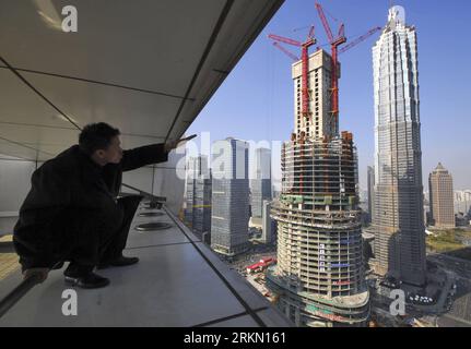 Bildnummer : 56903359 Datum : 17.01.2012 Copyright : imago/Xinhua (120117) -- SHANGHAI, 17 janvier 2012 (Xinhua) -- Un homme pointe le doigt sur la Tour de Shanghai (avant) en construction à côté de la Tour Jin Mao et du Shanghai World Financial Center à Shanghai, dans l'est de la Chine, le 17 janvier 2012. Les équipes de travail ont terminé les fondations du deuxième plus haut bâtiment du monde avant le calendrier prévu et se précipitent maintenant pour construire la structure au sol de la tour de Shanghai de 632 mètres, deuxième seulement après la Burj Khalifa de 828 mètres de haut à Dubaï. (Xinhua) (zgp) CHINA-SHANGHAI-SKYSCRAPER-CONSTRUCTION (CN) PUBLICATIONxNOTxINx Banque D'Images