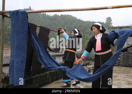 Bildnummer : 57109849 Datum : 04.01.2012 Copyright : imago/Xinhua (120226) -- HECHI, 26 février 2012 (Xinhua) -- la photo prise le 4 janvier 2012 montre deux femmes du groupe ethnique Yao accrochant des tissus faits maison pour les sécher dans le canton de Pingle, comté de Fengshan dans la région autonome de Guangxi Zhuang du sud de la Chine. Avec le développement des industries modernes, les techniques séculaires de filage à la main et de tissage au Guangxi sont confrontées à la menace de disparaître, car de nos jours la plupart ne portent plus de vêtements faits maison. (Xinhua/Zhou Enge) (llp) CHINE-GUANGXI-HECHI-TECHNIQUE DE FILAGE ET DE TISSAGE À LA MAIN-MENACE (CN) PUBLICATI Banque D'Images