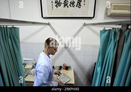 Bildnummer : 58003135 Datum : 18.05.2012 Copyright : imago/Xinhua (120518) -- HEFEI, 18 mai 2012 (Xinhua) -- Florian Paillard prépare du matériel médical à l'hôpital d'acupuncture et de moxibustion de l'Université de médecine traditionnelle chinoise d'Anhui à Hefei, capitale de la province d'Anhui, 13 février 2012. Florian Paillard, un Français de 27 ans, est étudiant de troisième cycle à l’Université de médecine traditionnelle chinoise d’Anhui, spécialisé en acupuncture, moxibustion et massage. Il est venu en Chine de Besançon, en France, il y a six ans, qui est également le lieu de naissance du célèbre écrivain Victor Hugo. T Banque D'Images