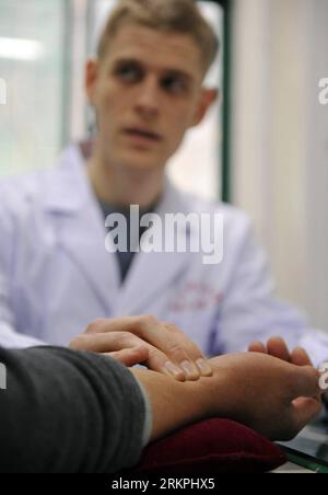 Bildnummer : 58003132 Datum : 18.05.2012 Copyright : imago/Xinhua (120518) -- HEFEI, 18 mai 2012 (Xinhua) -- Florian Paillard prend le pouls d'un patient à l'hôpital d'acupuncture et de moxibustion de l'Université Anhui de médecine traditionnelle chinoise à Hefei, capitale de la province d'Anhui, 13 février 2012. Florian Paillard, un Français de 27 ans, est étudiant de troisième cycle à l’Université de médecine traditionnelle chinoise d’Anhui, spécialisé en acupuncture, moxibustion et massage. Il est venu en Chine de Besançon, en France, il y a six ans, qui est également le lieu de naissance du célèbre écrivain Victor Hugo. Banque D'Images