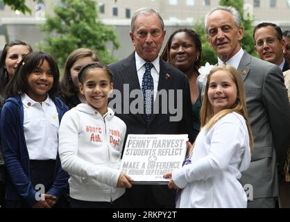 (120605) -- NEW YORK, 5 juin 2012 (Xinhua) -- Kyava Valdez (L en blanc), 10 ans, et Alyssa Majznor (R en blanc), 9 ans, présentent The future Book au maire de New York Michael Bloomberg (C) lors d’une cérémonie pour leur Penny Harvest pour la campagne commémorative 9/11 au 9/11 Memorial Plaza à New York, le 5 juin 2012. Les étudiants des cinq arrondissements de New York se sont réunis mardi au Mémorial du 9/11 septembre pour présenter un chèque de 57 000 $ pour soutenir la conservation de l'arbre survivant, une poire callery tirée des décombres du site du World Trade Center après les attaques du 2001 septembre et soignée Banque D'Images