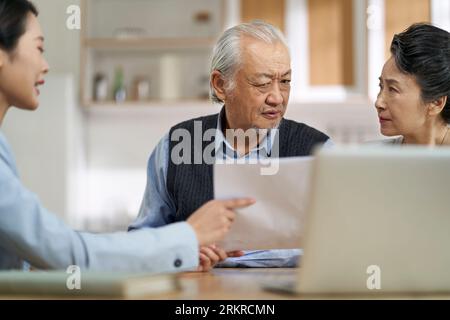 couple asiatique senior semble confus et suspect à un vendeur vendant des produits financiers Banque D'Images