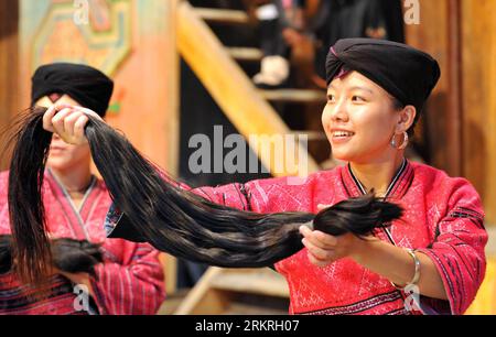 Bildnummer : 58246524 Datum : 15.07.2012 Copyright : imago/Xinhua (120716) -- GUILIN, 16 juillet 2012 (Xinhua) -- Une femme montre les cheveux coupés d'une fillette de 18 ans aux touristes du village Huangluo du groupe ethnique Yao à Guilin, dans la région autonome Guangxi Zhuang du sud de la Chine, le 15 juillet 2012. Le village Huangluo du groupe ethnique Yao est situé sur les terrasses de Longji dans la ville de Heping du comté de Longsheng à Guilin. Les femmes ici ont la tradition de garder les cheveux longs. Ils croient que les cheveux longs apportent chance et fortune. La longueur moyenne des cheveux de 180 femmes dans le village est de 1,7 mètres Banque D'Images