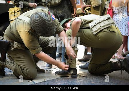 Avignon, France. 25th Aug, 2023. A soldier adjusts the uniform of another before the parade. Marking the 79th anniversary of Avignon's liberation in France during World War II, an exhibition showcasing a range of military and civilian vehicles unfolds in front of the town hall. (Photo by Igor Ferreira/SOPA Images/Sipa USA) Credit: Sipa USA/Alamy Live News Stock Photo