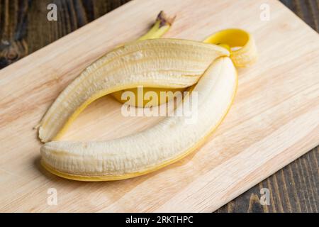 Banane jaune mûre pelée, coupe de banane pour la cuisson du dessert est sur la planche Banque D'Images