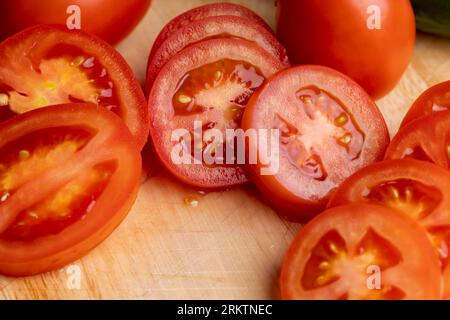 Émincé de tomates rouges fraîches sur un tableau, cuisant des salades à base de tomates et de concombres Banque D'Images