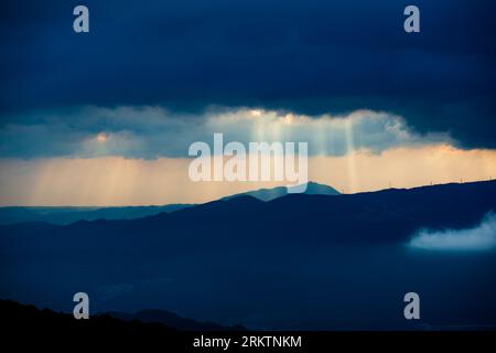 Attraper la lumière : rayons crépusculaires au milieu des nuages en constante évolution de la montagne. La station radar météorologique Wufenshan se trouve au sommet de la montagne. Ta Banque D'Images