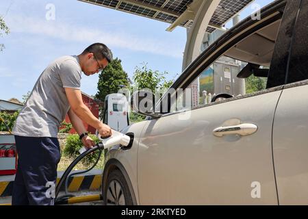 Jinan, China's Shandong Province. 31st May, 2023. A man charges his electric vehicle at a charging station in Zhujiahu Village of Yiyuan County, east China's Shandong Province, May 31, 2023. Credit: Zhu Zheng/Xinhua/Alamy Live News Stock Photo