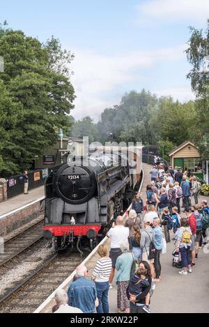 9F 92134 steam train arriving at Pickering station with a crowd of passengers waiting on the platform, NYMR, North Yorkshire, England, UK Stock Photo