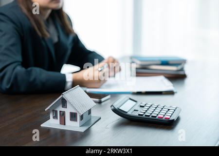 Les banques approuvent les prêts pour acheter des maisons. Les agents immobiliers expliquent le document pour les clients qui viennent à contacter pour acheter une maison, acheter ou vendre une société immobilière Banque D'Images