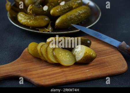 Tranches de concombre marinées sur planche de bois. Cornichons de concombres marinés Banque D'Images