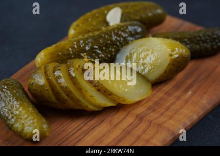 Tranches de concombre marinées sur planche de bois. Cornichons de concombres marinés Banque D'Images