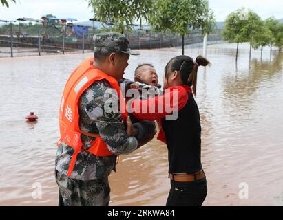 Bildnummer: 58649364  Datum: 29.10.2012  Copyright: imago/Xinhua (121030) -- FANGCHENGGANG, Oct. 30, 2012 (Xinhua) -- A Chinese soldier hands over a Vietnamese baby he rescued from the flood to his mother at a waterlogged market near the China-Vietnam border river Beilun in Dongxing, south China s Guangxi Zhuang Autonomous Region, on Oct. 29, 2012. Typhoon Son-Tinh has brought strong wind and downpours to Guangxi since Sunday, sinking six boats and causing another 70 to go missing on a China-Vietnam border river, police said Tuesday. Maritime authorities in Guangxi rescued 26 Vietnamese women Stock Photo