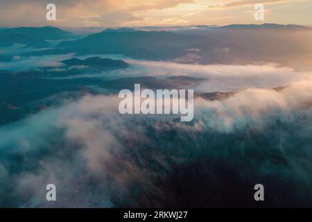 Vue panoramique sur la montagne. Paysage nuageux aérien avec des nuages roulant sur les crêtes brumeuses des montagnes Banque D'Images