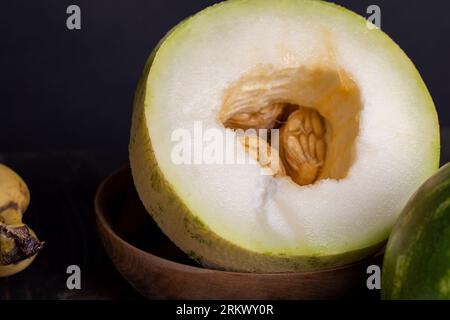 Pulpe de melon douce mûre divisée en petits morceaux, pulpe de melon mûre coupée sur une planche à découper dans la cuisine Banque D'Images