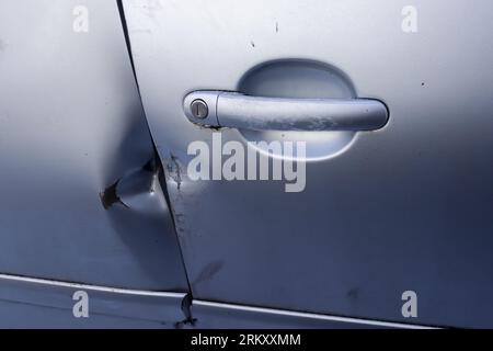 Porte de voiture avec marques de rodage provenant d'Un Crow-bar près de la poignée Banque D'Images