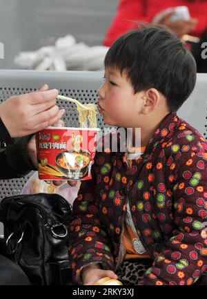 Bildnummer : 59138005 Datum : 26.01.2013 Copyright : imago/XINHUA (130126) -- YINCHUAN, 26 Jan. 2013 (Xinhua) -- Un enfant mange des nouilles instantanées en attendant un train à la gare de Yinchuan à Yinchuan, capitale de la région autonome hui de Ningxia, dans le nord-ouest de la Chine, le 26 janvier 2013. Alors que le festival du printemps, qui tombe le 10 février de cette année, approche, beaucoup se sont précipités pour commencer leur voyage de retour. (Xinhua/Peng Zhaozhi) (ry) CHINA-SPRING FESTIVAL-TRAVEL RUSH (CN) PUBLICATIONxNOTxINxCHN Gesellschaft Verkehr Bahn Reisewelle Kinder Bahnhof Frühlingsfest x0x xst 2013 hoch 59138005 Date 26 01 2 Banque D'Images