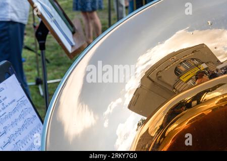 26 August 2023, Brandenburg, Cottbus: A 'Theater-Stadt-Fest' poster attached to the Cottbus State Theater's Great House is reflected in a trombone at a play-along concert during the Cottbus State Theater's opening event for the new season. 'Together. Here.' is the motto of the Cottbus State Theater for the 2023/24 season, which the Brandenburg four-speaker theater is celebrating this weekend together with citizens. A total of 19 premieres in the drama, musical theater and ballet divisions, eight philharmonic concerts and numerous events in the 'Special Format' and 'Special' series will be expe Stock Photo