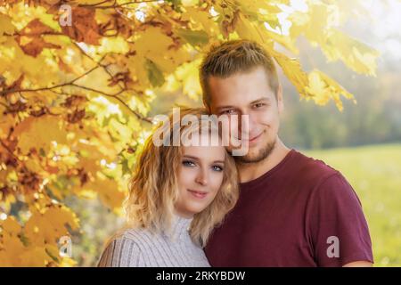 Un jeune couple aimant pose dans le parc d'automne. Horizontalement. Banque D'Images