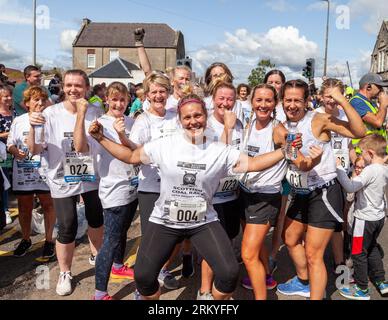 Concurrents après avoir terminé les Scottish Coal Carriing Championships. Les hommes portent des sacs de charbon de 50 kg et les femmes portent des sacs de 25 kg sur un parcours de 1 km dans les rues de Kelty à Fife Banque D'Images