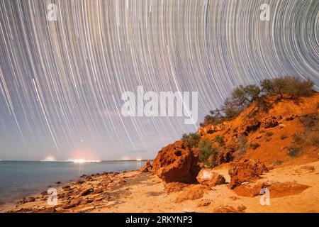 Sentiers d'étoiles au-dessus des rochers rouges à Shark Bay, Australie occidentale Banque D'Images