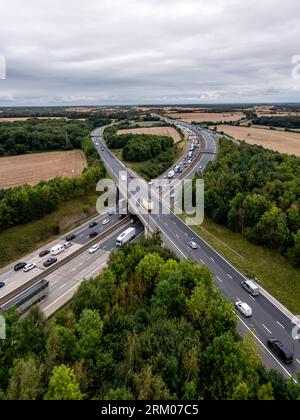 Paysage aérien de vertorama d'un tronçon occupé de l'autoroute M1 à un croisement avec la file d'attente de circulation et se rejoignant sur la chaussée principale Banque D'Images