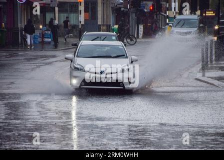 Londres, Royaume-Uni. 26 août 2023. Une voiture éclabousse une grande flaque d'eau dans le centre de Londres tandis qu'une douche de pluie arrose la capitale. Crédit : Vuk Valcic/Alamy Live News Banque D'Images