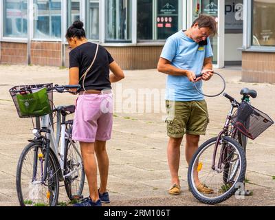 Couple enfermant des vélos dans le centre mignon - Tours, Indre-et-Loire (37), France. Banque D'Images