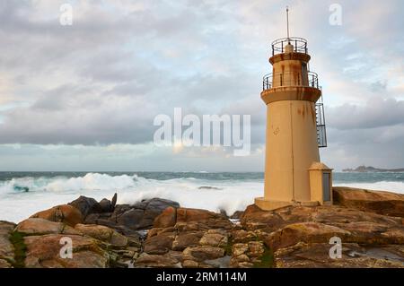 Phare de Punta da Barca près du sanctuaire Virgen da Barca avec mer agitée (Muxía, Costa da Morte, Fisterra, A Coruña, Galice, mer Atlantique, Espagne) Banque D'Images