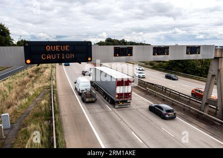 LEEDS, ROYAUME-UNI - 25 AOÛT 2023. Un panneau d'avertissement au-dessus d'une autoroute gérée par le Royaume-Uni avertissant les automobilistes de réduire leur vitesse et de prendre des précautions en raison d'un q Banque D'Images