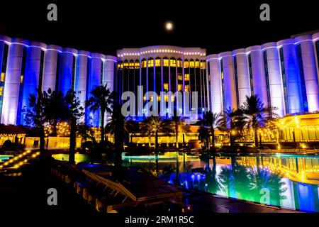 The Ritz-Carlton Bahrain, éclairé la nuit.vue depuis la zone des piscines, espace de villégiature Banque D'Images