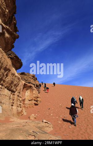 Touristes à Al Ramal Red Sand Dune, Wadi Rum, site du patrimoine mondial de l'UNESCO, Jordanie, Moyen-Orient Banque D'Images