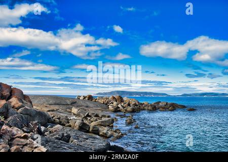 Côte rocheuse avec de grands rochers de granit sur une journée ensoleillée d'été. Au loin, la côte du parc national de Torndirrup, Albany, Australie occidentale Banque D'Images