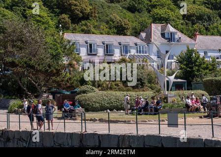 Herm Island, îles Anglo-Normandes, 11 juin 2023. Vacanciers à The Herm, Harbour avec en toile de fond un hôtel dans les îles Anglo-Normandes Banque D'Images