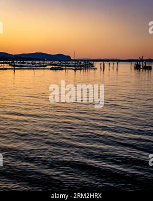 Piermont, NY - US - 20 août 2023 vue verticale d'un coucher de soleil sur la rivière Hudson et les marinas de Piermont avec reflets. Banque D'Images