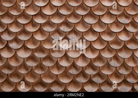 Bardeaux à fond rond en bois de parement mural de la ferme historique. Motif de bardeaux de bois, toit ou façade. Texture d'architecture traditionnelle en bois. Banque D'Images