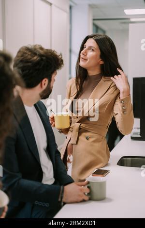 Une femme brune a donné une idée « après le travail » à ses collègues. Elle attend leur réponse Banque D'Images