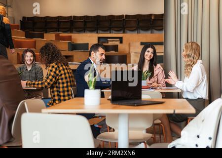 Groupe diversifié de personnes d'âge tous assis séparément au bureau Banque D'Images